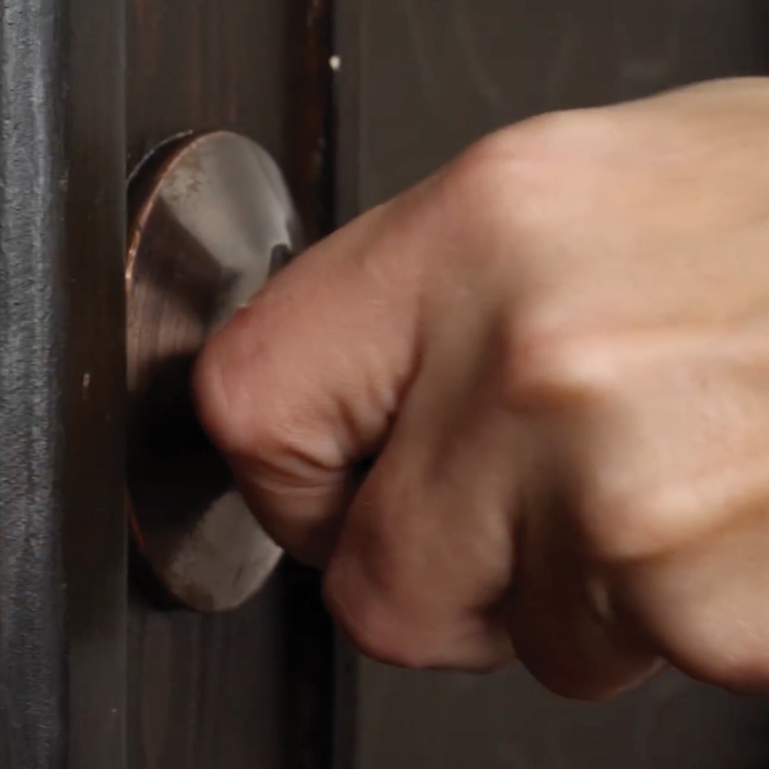 A hand on a door knob.