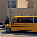 A yellow school bus parked outside a school.
