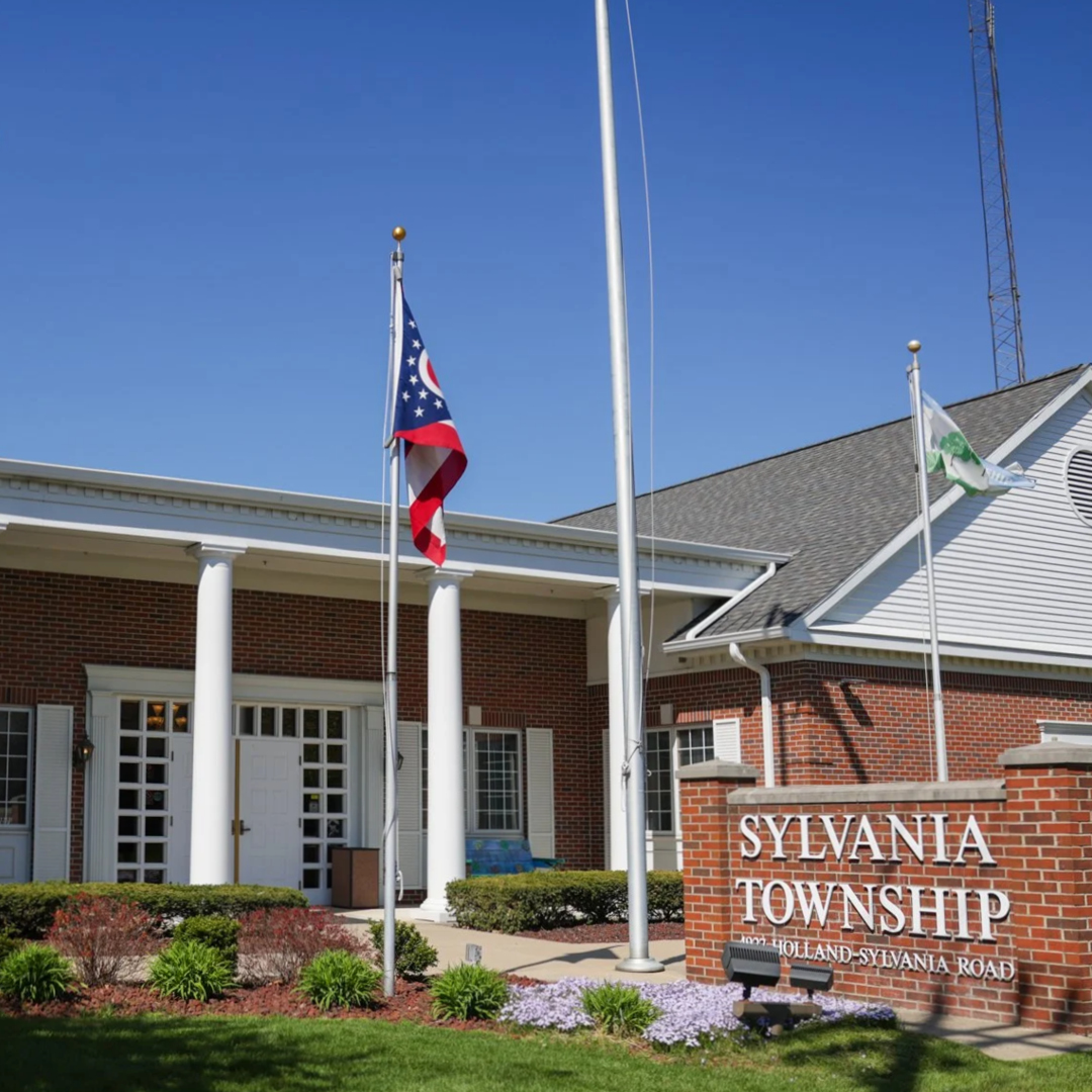 A brick building with white columns in front and a brick sign that says 'Sylvania Township.'