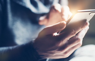 A hand holding a mobile phone.