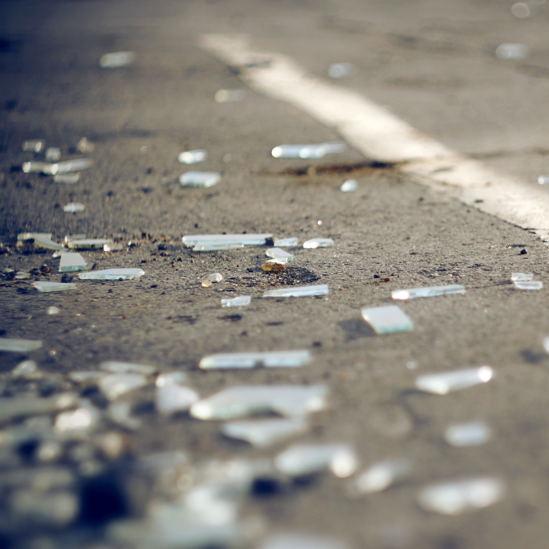Shards of broken glass on asphalt.