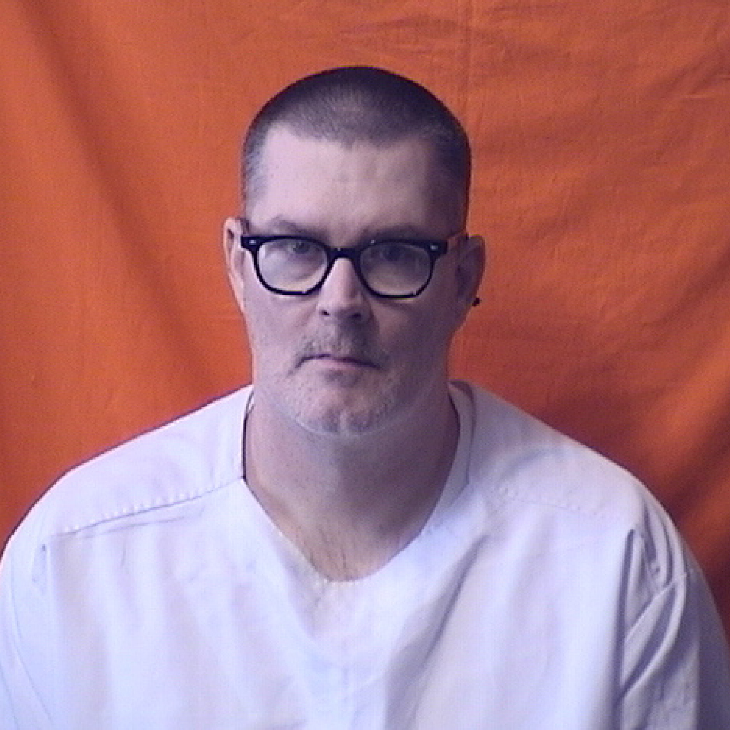 A man in a white shirt with glasses