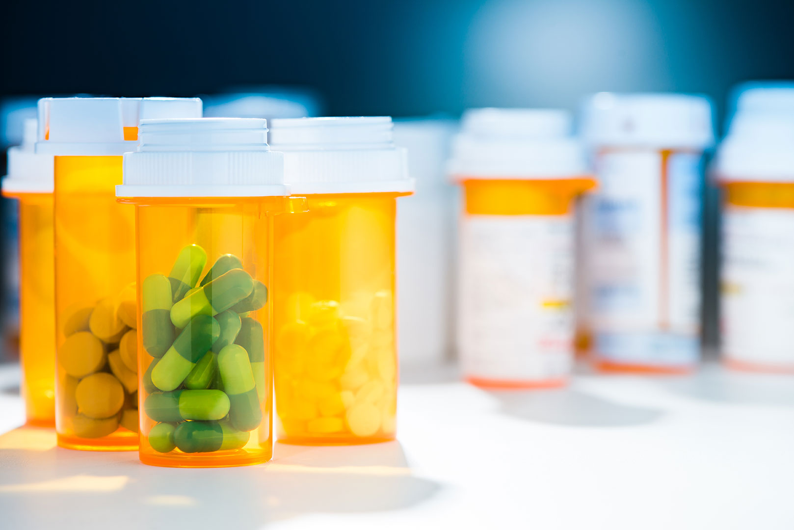 Several amber-colored prescription pill bottles with white caps.