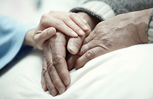 Image of a hand resting on the hand of another