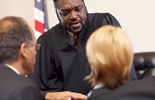 Image of a judge talking to two attorneys. (Fuse/Thinkstock) Image of a judge talking to two attorneys