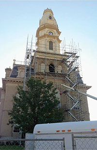 Image of the exterior of the Logan County courthouse with scaffolding in front of it as it undergoes repairs