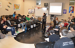 Image of a woman in a business suit speaking to a classroom of students Image of a woman in a business suit speaking to a classroom of students