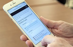 Image of hands holding a smartphone with the redesigned Supreme Court online case management system on the screen Image of hands holding a smartphone with the redesigned Supreme Court online case management system on the screen