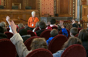 Image of students in the courtroom with a tour guide. Image of students in the courtroom with a tour guide.
