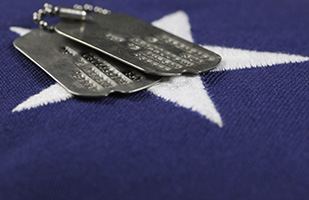 Image of a close-up view of a white star on the blue background of the American Flag with a set of military dog tags resting on top (Thinkstock)