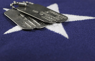 Image of a close-up view of a white star on the blue background of the American Flag with a set of military dog tags resting on top (Thinkstock) Image of a close-up view of a white star on the blue background of the American Flag with a set of military dog tags resting on top (Thinkstock)