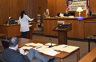 Image of a man speaking from a podium in a courtroom of the Cleveland Municipal Court