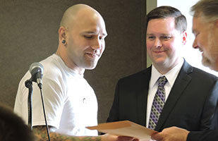 Image of a man receiving a certificate from another man Image of a man receiving a certificate from another man