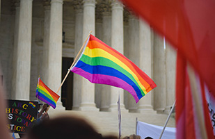 Image of the rainbow flag associated with the LGBT community on the steps of the U.S. Supreme Court