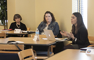 Image of three women, one talking, sitting at a table Image of three women, one talking, sitting at a table