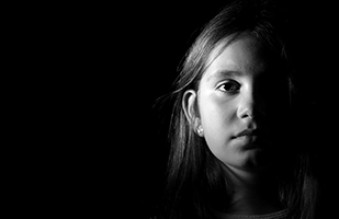 Image of a little girl's face surrounded by darkness Image of a little girl's face surrounded by darkness