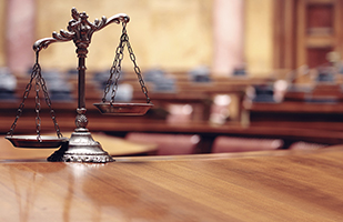 Image of the scales of justice sitting on a wooden table