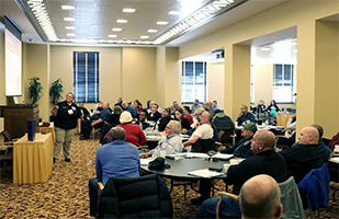 Image of a woman speaking to a roomful of people