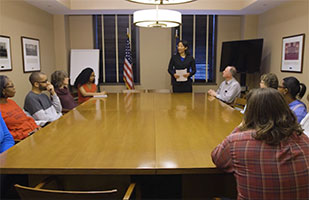 Image of a group of people seated around a table in a conference room
