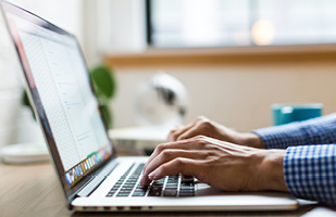 Image of hands on a laptop computer keyboard