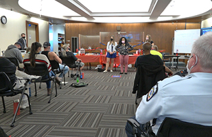 Image of 2 women in a Courtroom facing several others in the audience