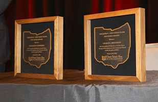 Wooden frames with a state of Ohio-shaped plaque detailing the award winner.