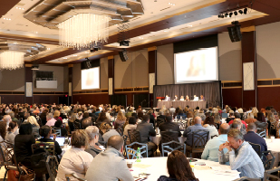 Image of a large room full of people sitting at round tables