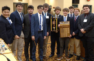 Image showing 10 young men, all wearing suits, one man is holding a trophy and another is holding a plaque.