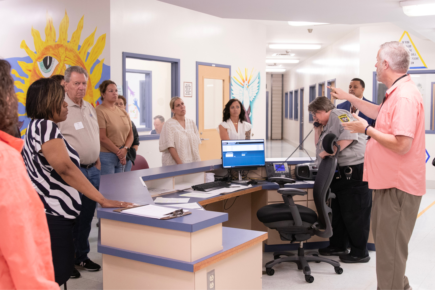A group of men and women listen to a man give instructions.