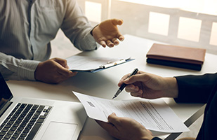 Image showing a lawyer and clients hands gesturing towards legal documents