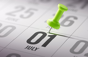 A calendar with a green push pin on July 1