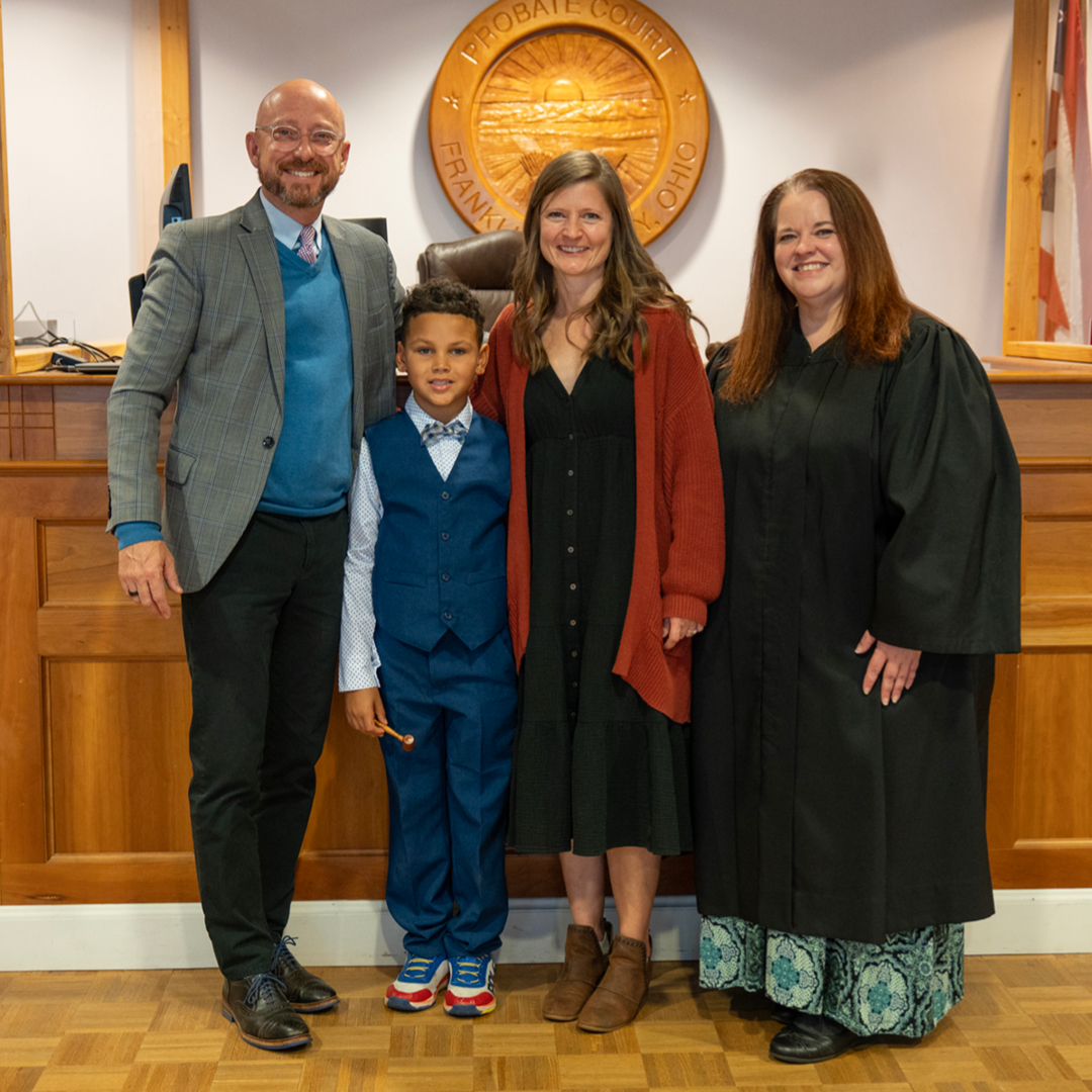 Two adults with a child and a judge in a courtroom