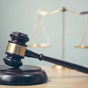 A gavel on a table with a scale in the background