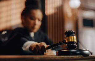 A judge in a courtroom holding a gavel