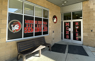The doors of the Monroe Central High School with a Seminole icon
