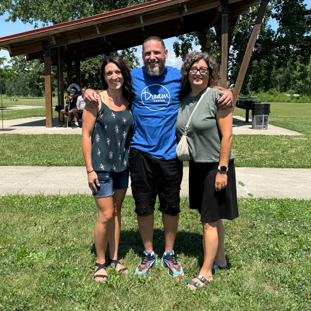 A man and two women smiling at the camera