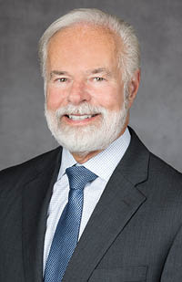 A man wearing a grey suit and blue tie.