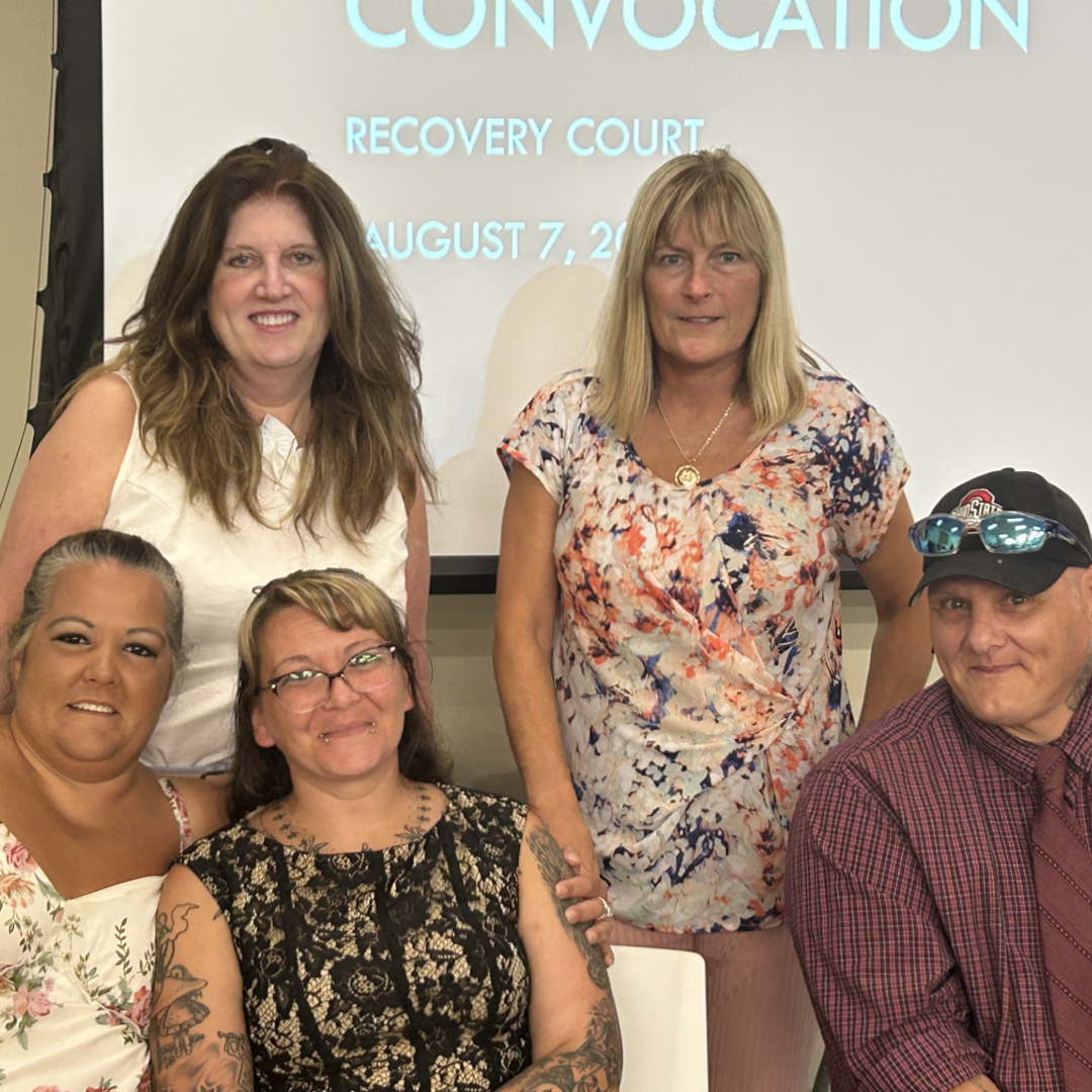A group of five people smiling at the camera