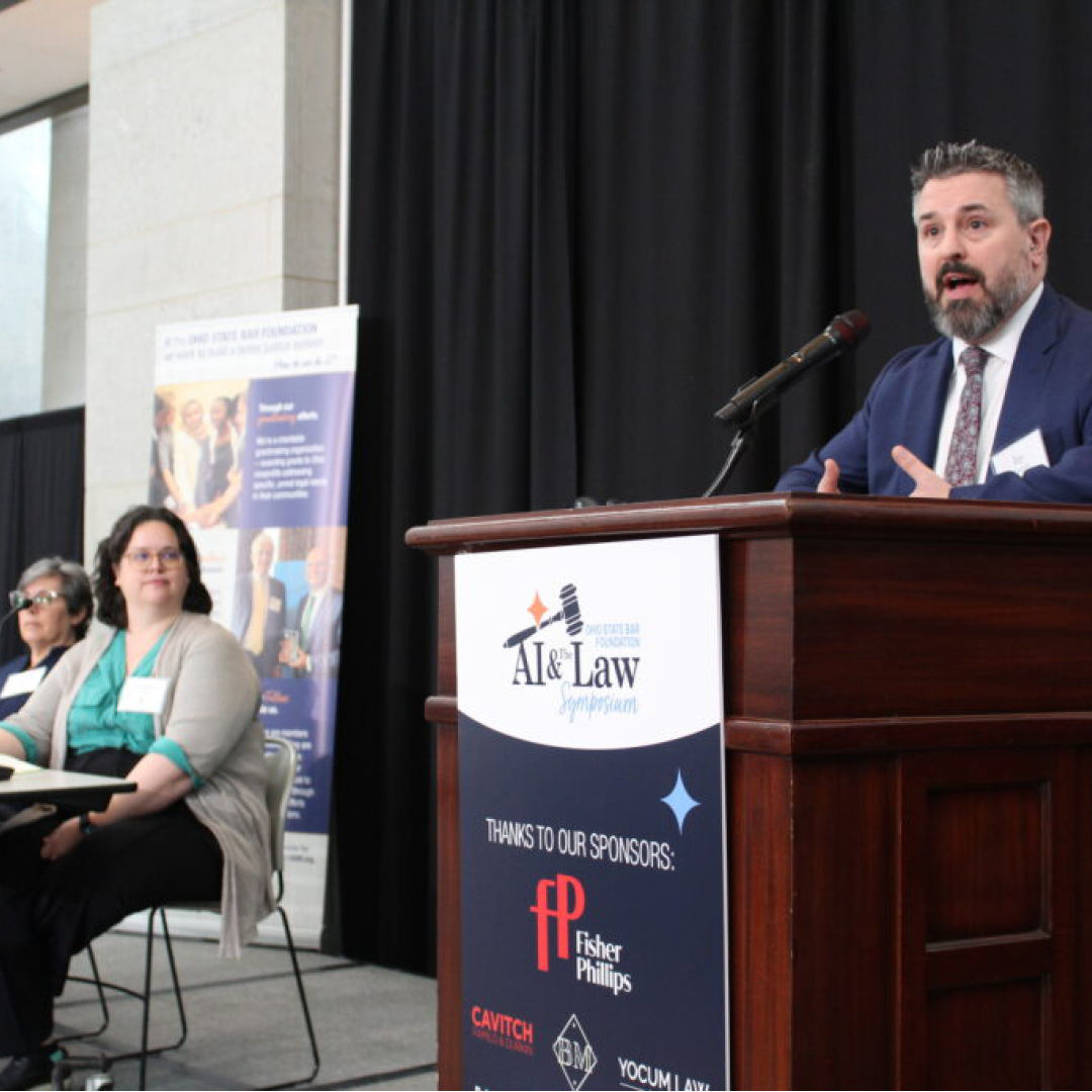A man speaking at a podium to a large crowd