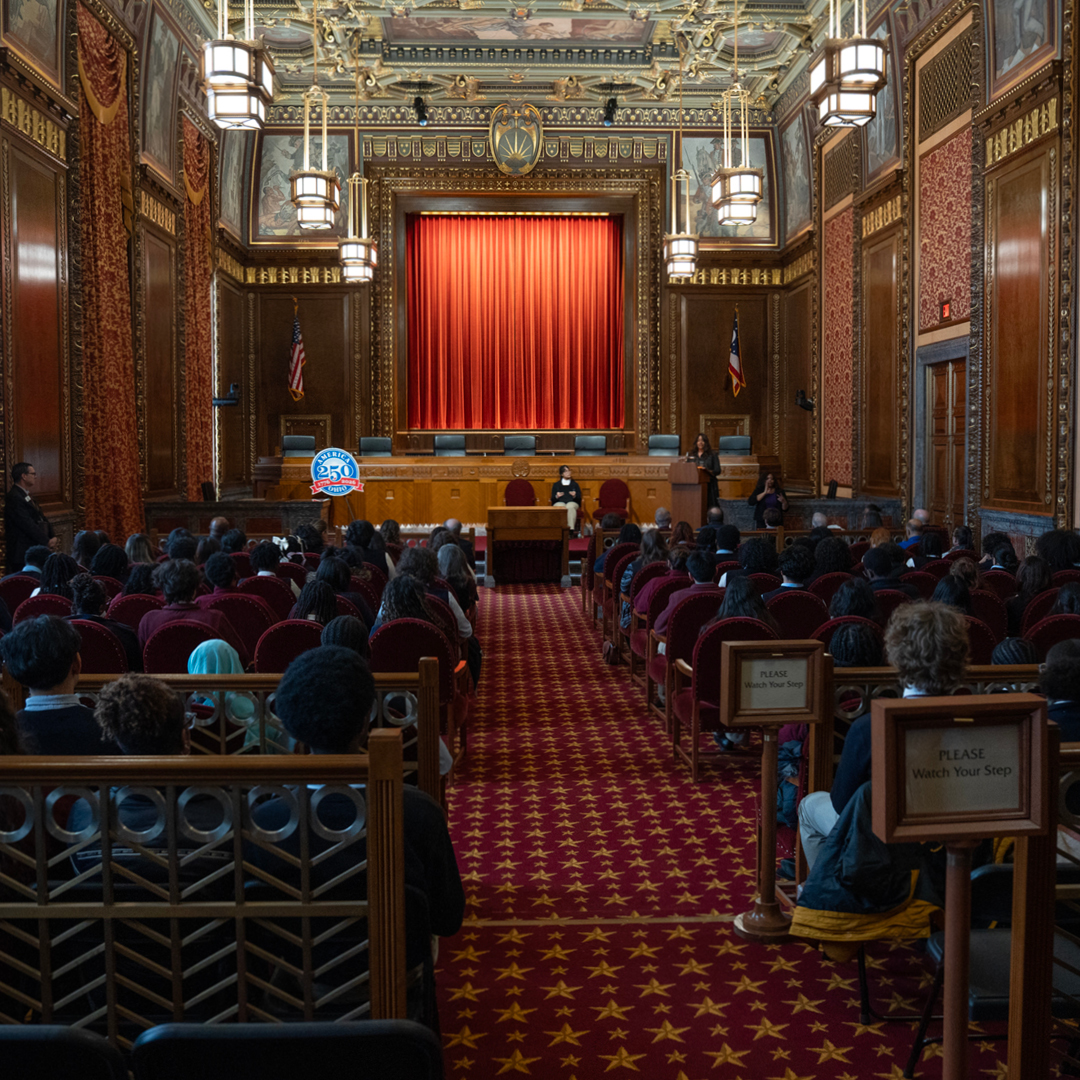 The Thomas J. Moyer Ohio Judicial Center with a speaker at a podium and a large audience sitting in chairs