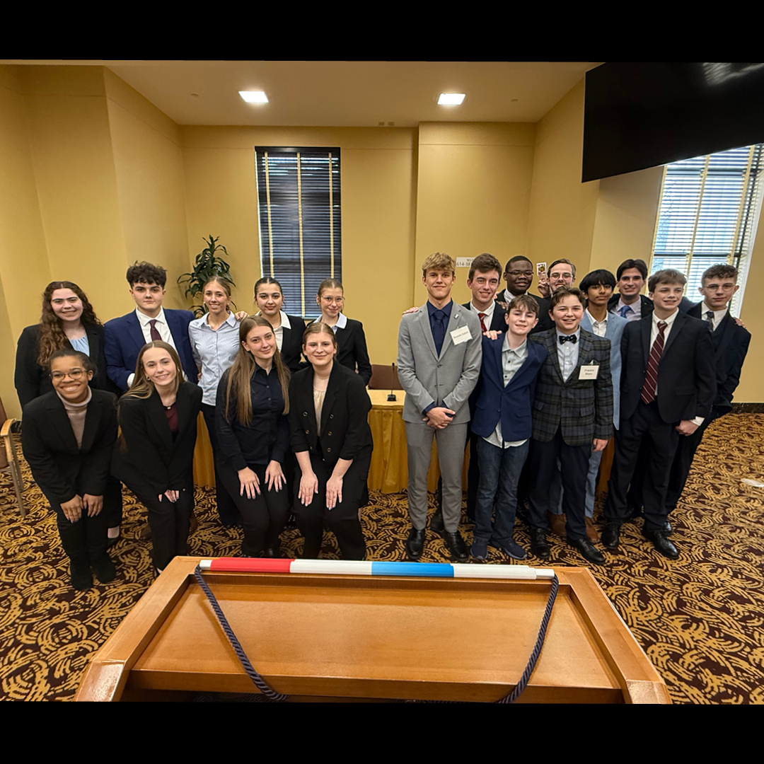 Twenty teens wearing business attire smiling