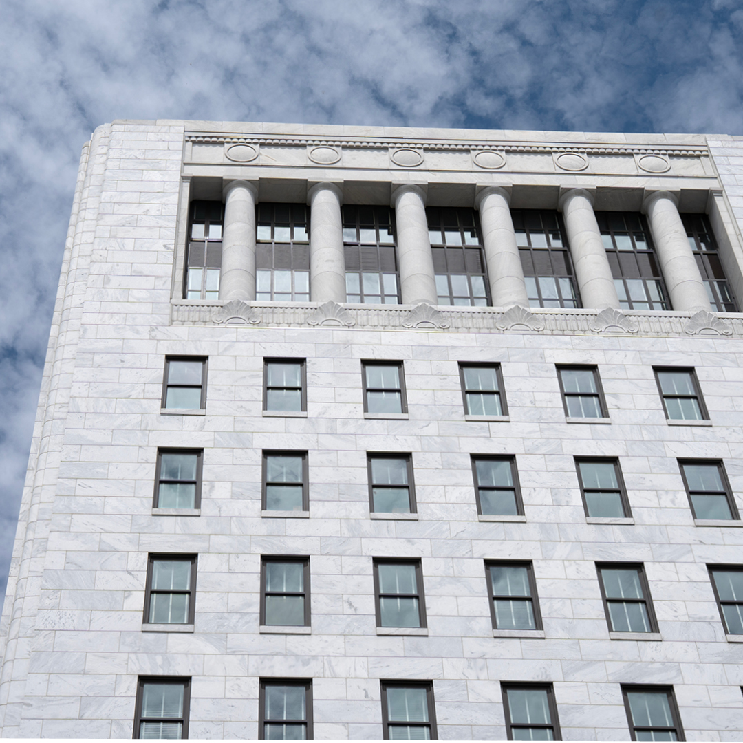 A marble building with windows and a blue sky