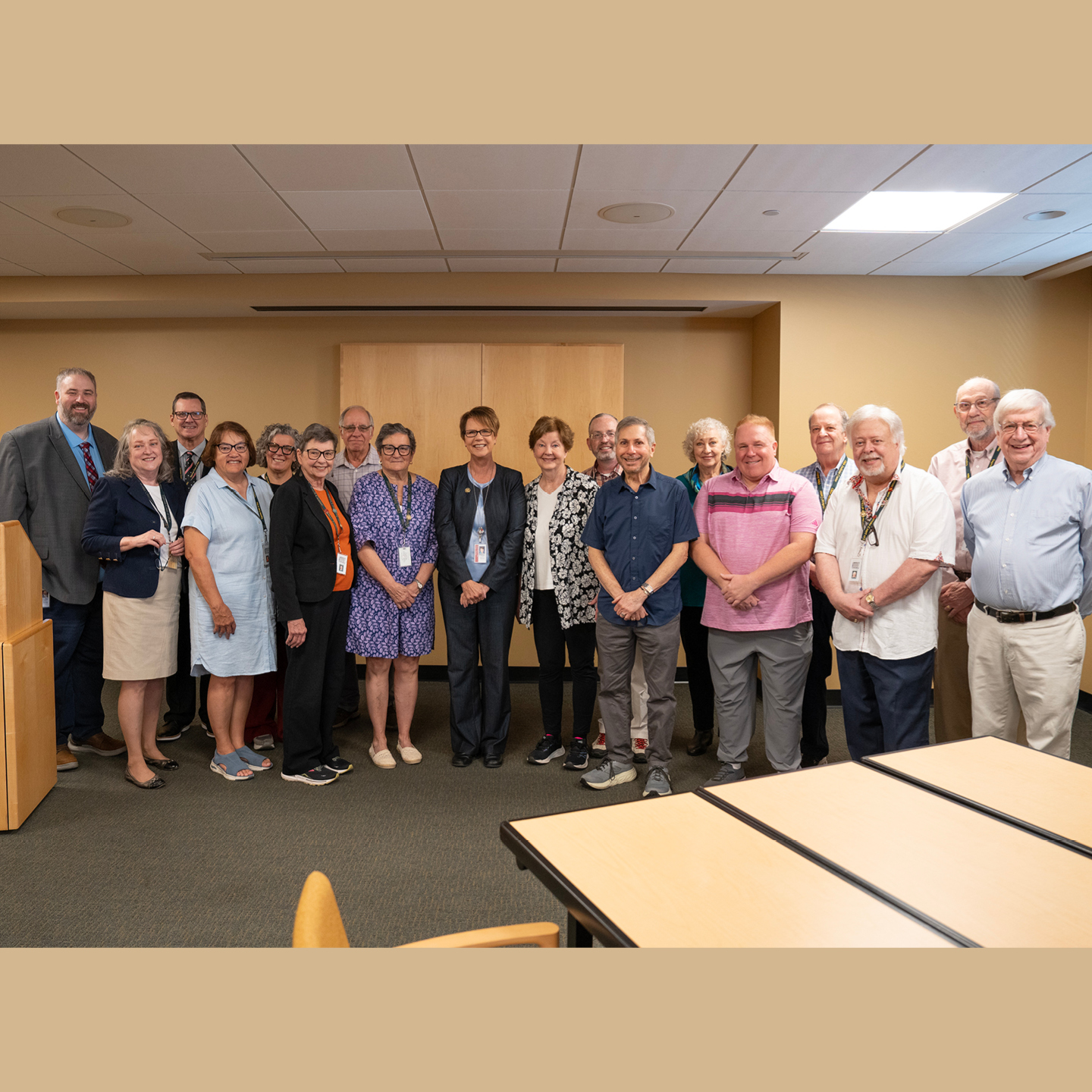 A group of 18 people smiling for a group photo