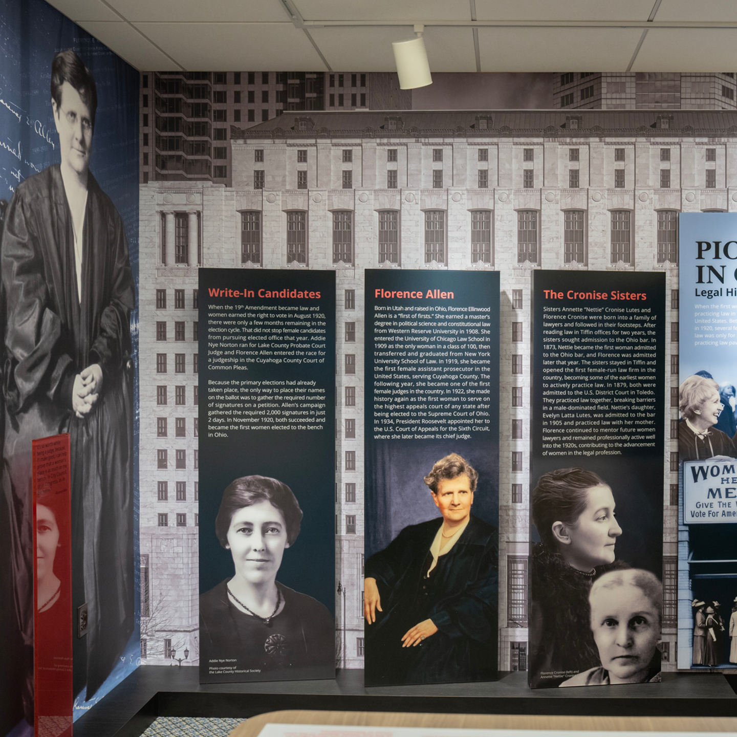 Exhibit on women in Ohio's legal history featuring panels on write-in candidates, Florence Allen, and the Cronise Sisters, with historical photographs and information about women's suffrage.