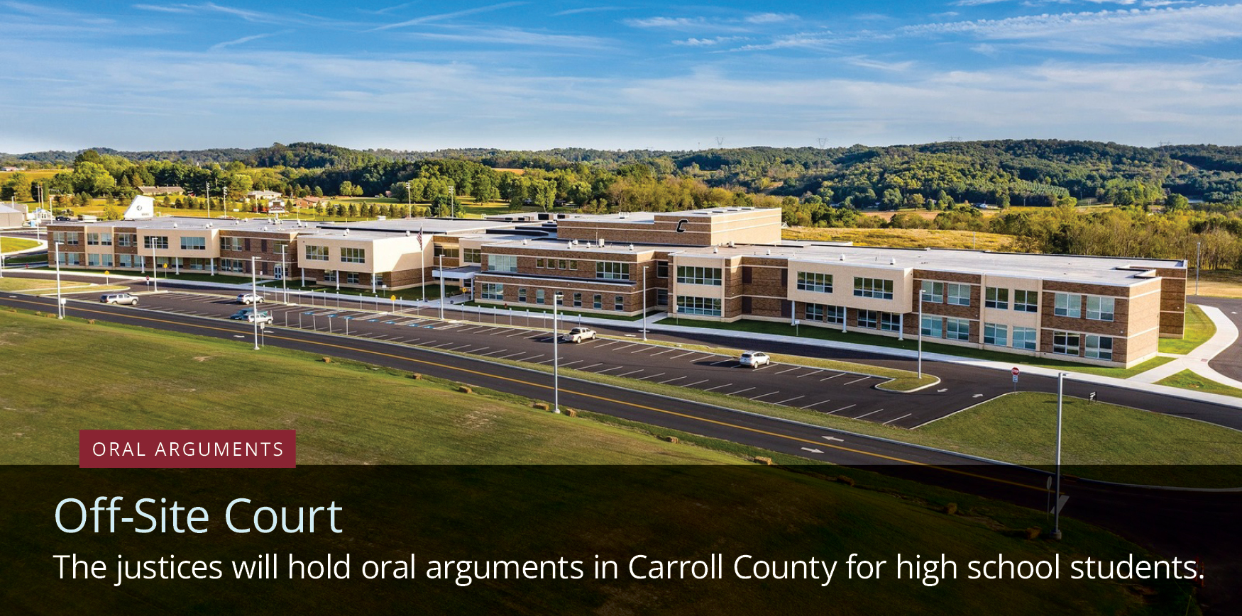 A school surrounded by hills with text reading 'Oral Arguments, Off-Site Court, The justices will hold oral arguments in Carroll County for high school students.'