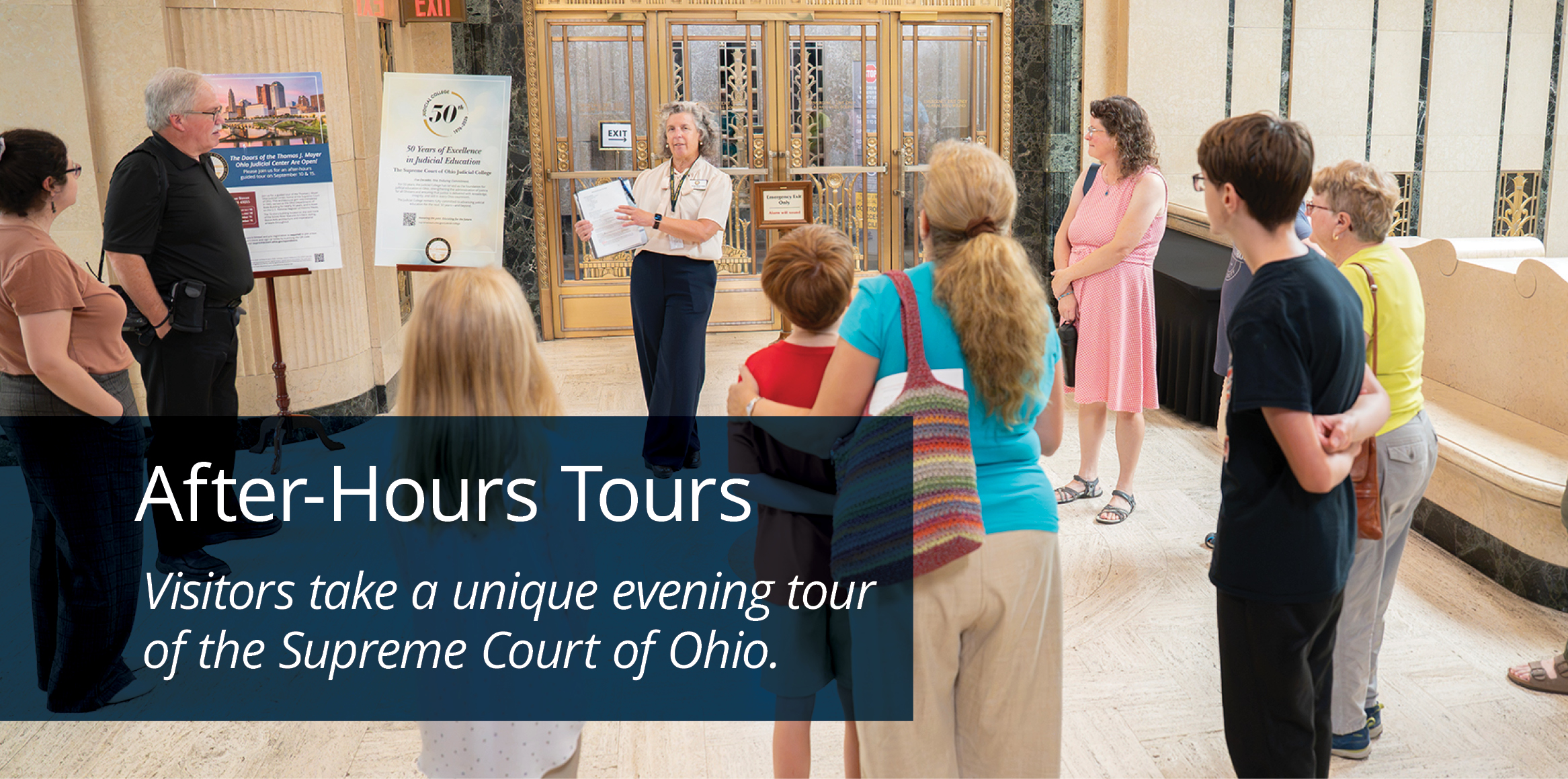 Visitors listen to a guide during an after-hours tour of the Supreme Court of Ohio in an ornate marble lobby.
