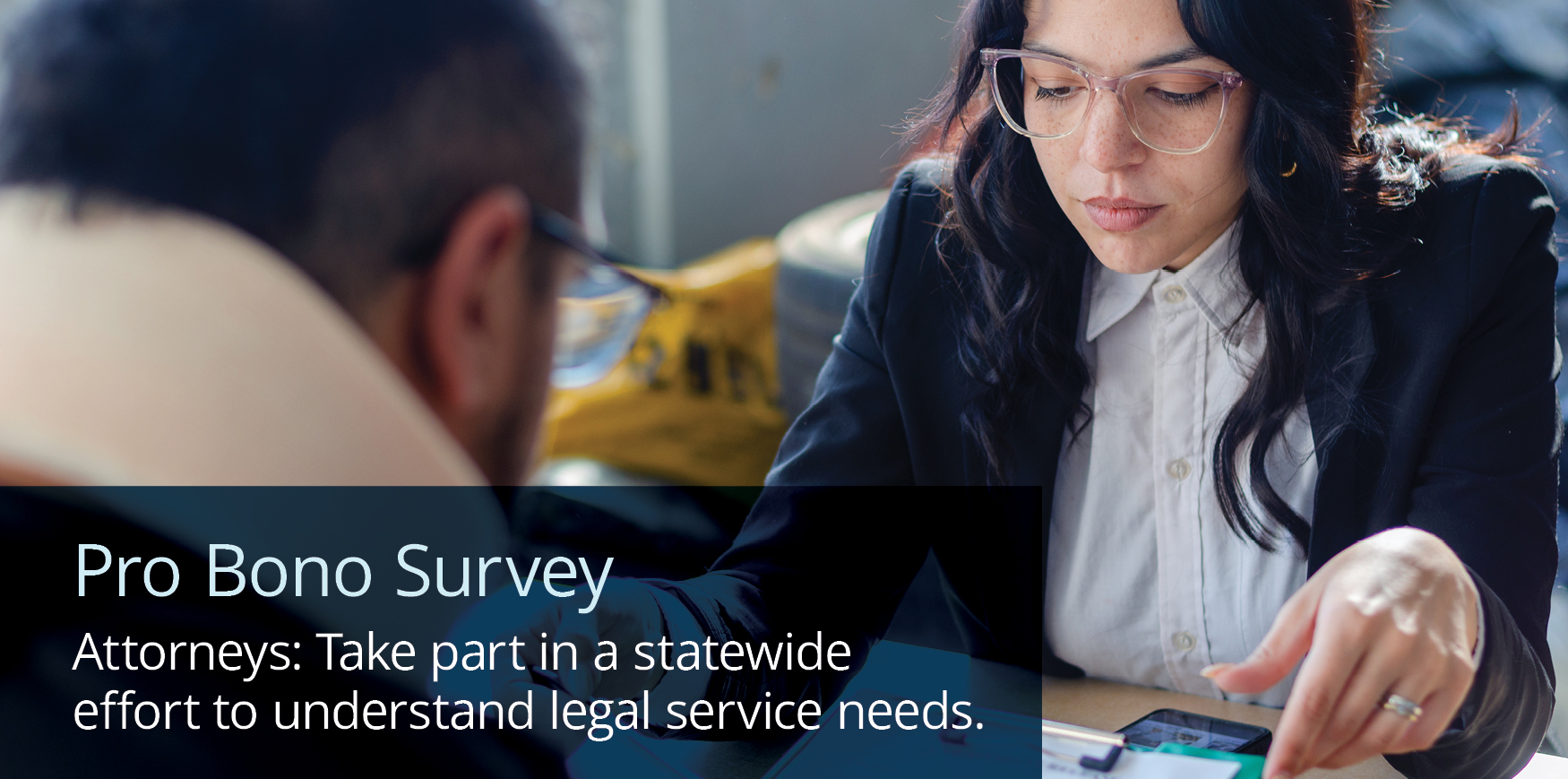 A woman and a man looking over documents on a desk with text reading 'Pro Bono Survey. Attorneys: Take part in a statewide effort to understand legal service needs.'