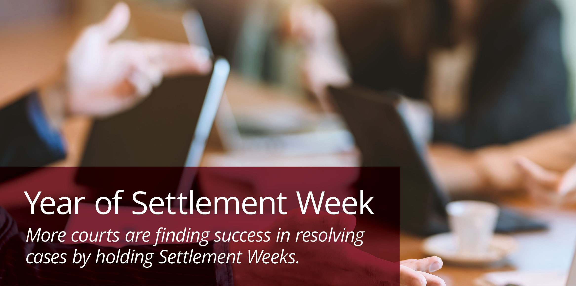Blurred meeting scene with people discussing around laptops. Foreground text reads, 'Year of Settlement Week,' highlighting successful court case resolutions.