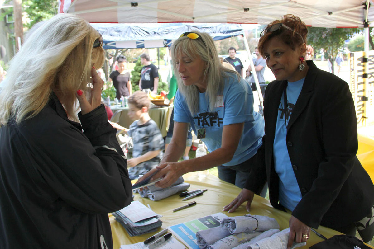 Image of three women at an outdoor event information booth
