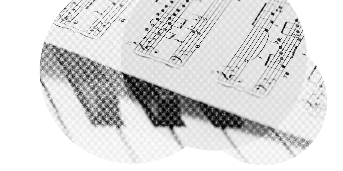 Image of a piano keyboard with sheet music on top of it